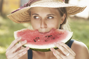 Beautiful young woman eating watermelon. Vitamins, nutritional vegetarian food, holiday, diet concept.