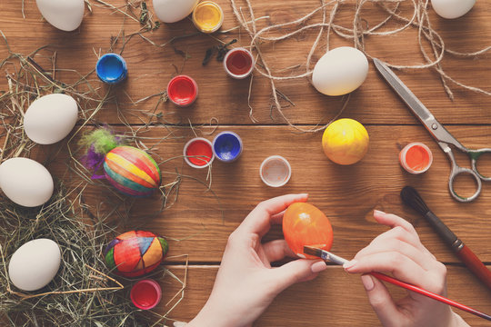 Painting colorful easter eggs, top view on wood