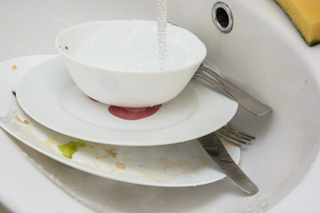 Wash the dishes in the kitchen