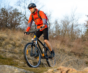 Fototapeta na wymiar Enduro Cyclist Riding the Mountain Bike on the Rocky Trail. Extreme Sport Concept. Space for Text.
