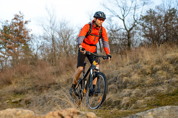 Fototapeta na wymiar Enduro Cyclist Riding the Mountain Bike on the Rocky Trail. Extreme Sport Concept. Space for Text.
