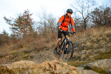 Enduro Cyclist Riding the Mountain Bike on the Rocky Trail. Extreme Sport Concept. Space for Text.