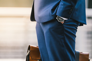 Closeup Of A Businessman wear the watch and Holding leather Briefcase Going To Work with the...