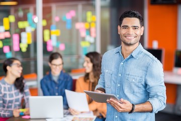 Portrait of male executive holding digital tablet
