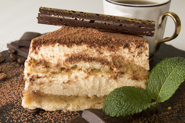 Piece of tiramisu cake on black slate