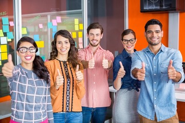 Portrait of smiling executives showing thumbs up