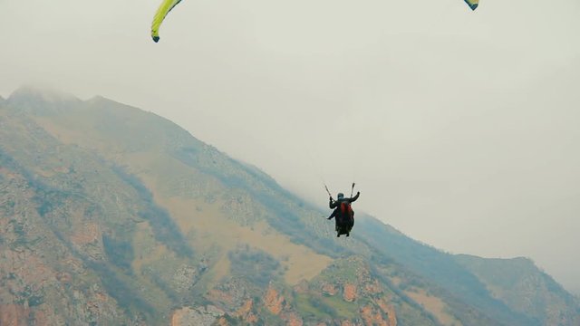 Flight of a tourist on a paraglider against the backdrop of beautiful mountains