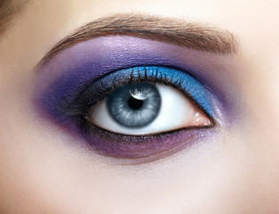 Obraz premium Female eye with blue and violet makeup