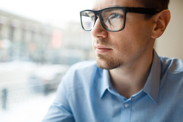 Obraz premium Modern young businessman in eyeglasses and blue shirt