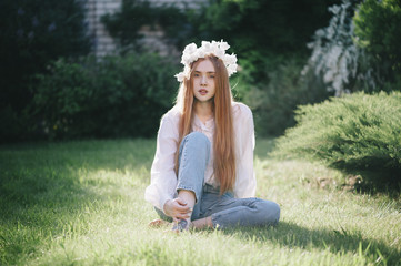 Beautiful redhead young woman contemplating in a deep thought in the summer park