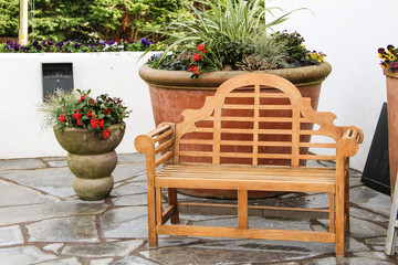 large flower pot , smaller flower pot and a bench