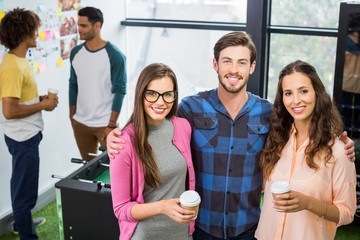 Portrait of smiling executives standing with arms around