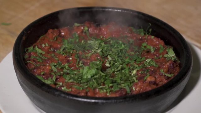 Frying bens in tomato sauce in the pot, slow motion