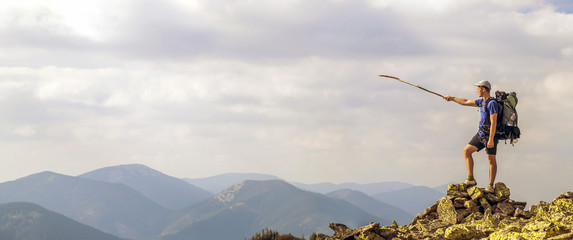 Man on peak of mountain. Emotional scene. Young man with backpac