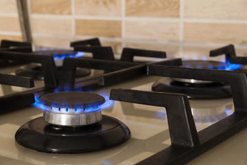 Closeup shot of blue fire from domestic kitchen stove. Gas cooker with burning flames propane gas.