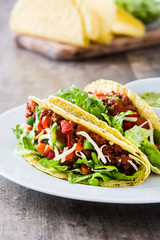 Traditional Mexican tacos with meat and vegetables on wooden background
