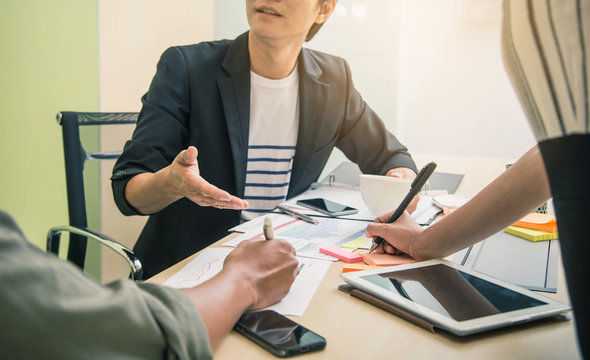 Brainstorming Group of people Working Concept. Business team brainstorming. Marketing plan researching. Paperwork on the table, laptop and mobile phone.