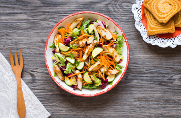 Salad of chicken breast with zucchini and cherry tomatoes, on a wooden background