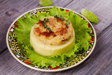 Fish patty with mashed potato and lettuce. View from above, top studio shot
