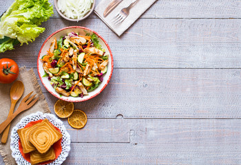 Salad of chicken breast with zucchini and cherry tomatoes, on a wooden background