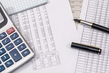 business concept  - financial reports with calculator, pen.