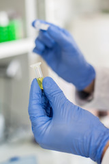 Lab technician holding a test tube with sample