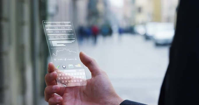 A businessman in the city, use the transparent phone with latest technology security code fingerprint. Concept: technology, business, security and internet banking, future