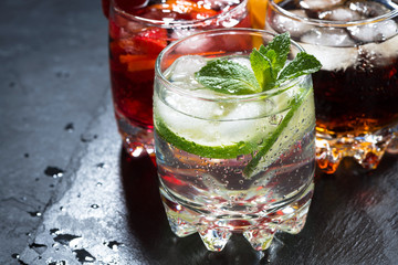 assortment of iced fruit drinks on a dark background, closeup