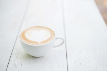 Cup of coffee on a white wooden background.