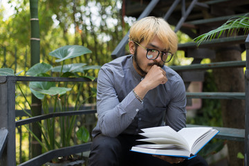Fototapeta premium Young handsome beard man reading book. Learning or Education concept.