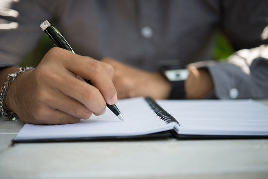 Man hand writing on notebook.