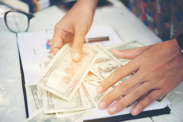 Woman with money at workplace. Business concept.