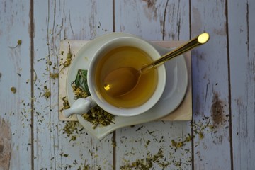 Herbal tea on top of books with white wood background