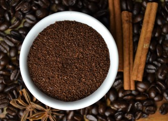 Coffee grounds with coffee beans and cinnamon sticks