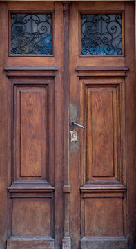 Old vintage wooden brown door close-up with insertions and patterns on glass