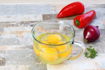 Making egg omelette with cut onion, red pepper  &  garden cress