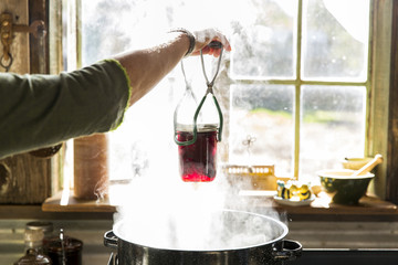 Person preserving food by cooking jars
