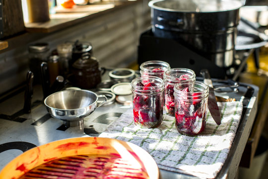 Preserves jars of beetroot on tea towel in kitchen
