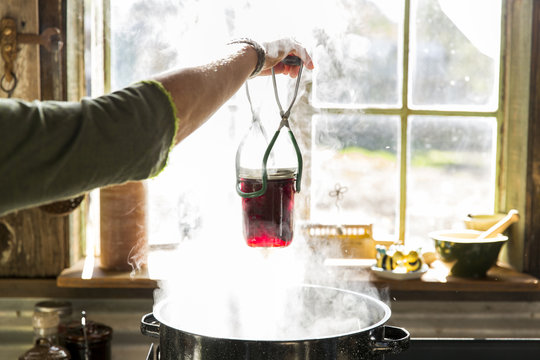 Person preserving food by cooking jars