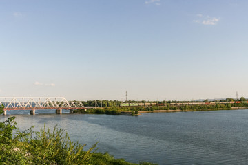 Fototapeta na wymiar Railway bridge through the river Volga and freight train is movi