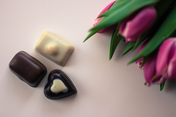 Obraz na płótnie Canvas Pink tulips and chocolate candies