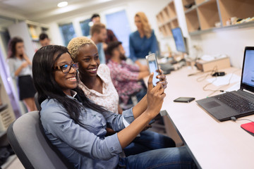 Female coworkers working at company taking selfie