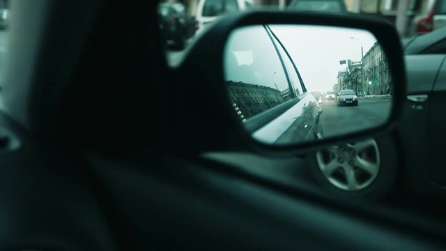 The view from the side mirror. Cars overtake each other.