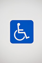 Handicap accessibility sign surrounded by white background.
