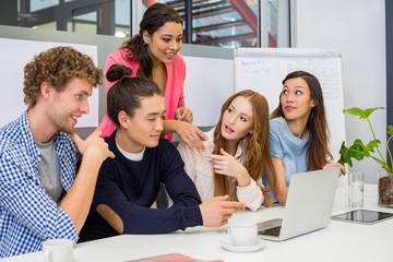 Executives discussing over laptop in conference room