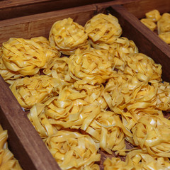 Uncooked Tagliatelle Italian Pasta in Wooden Box