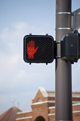 Electronic crosswalk sign with warning hand signal.