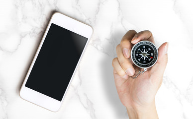 Blank smartphone screen with hand on compass for GPS mobile application mock up