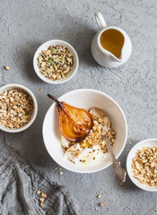 Caramelized baked pears with greek yogurt and granola on a gray background, top view. Healthy breakfast