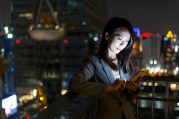 Businesswoman working on cellphone at night